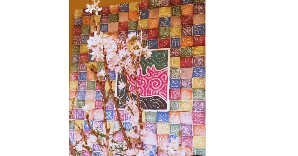 アンディ・レイキーの天使の絵に桜の花が添えられた写真。色とりどりのシンボルが並ぶ作品には、祈りと癒しのエネルギーが宿っています。